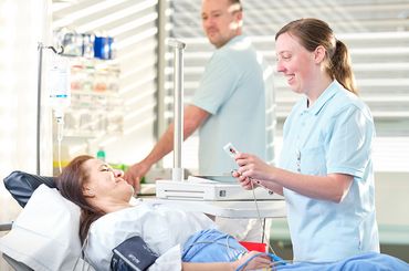 Pflegefachpersonen kümmern sich um eine Patientin