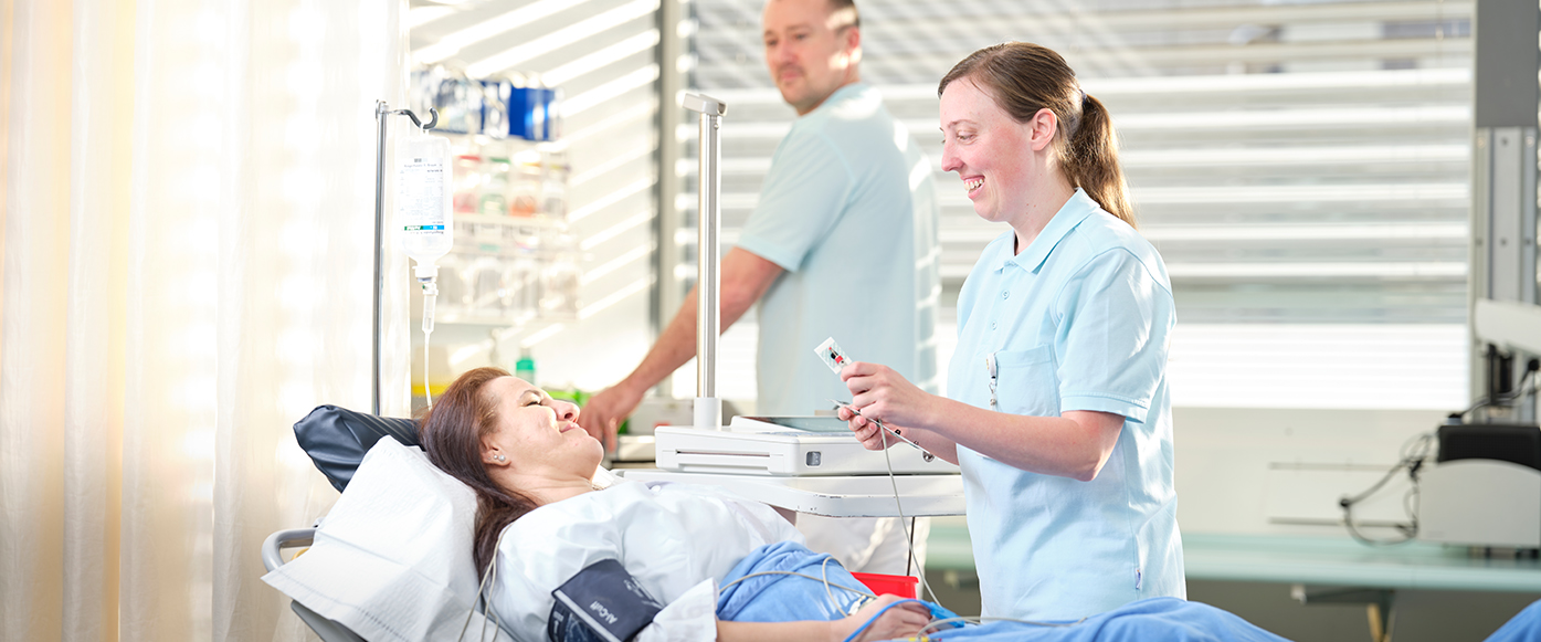 Pflegefachpersonen kümmern sich um eine Patientin
